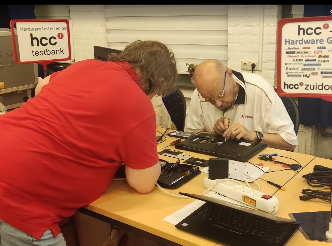 twee mensen gebogen over een computer waar ze aan werken