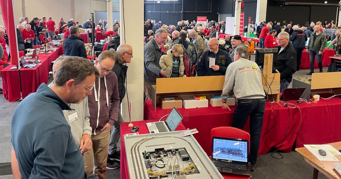 een groep mensen die een stand van HCC bekijken